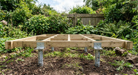 Ground screw post anchors carrying a timber deck frame above garden soil