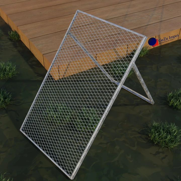 Garden sieve with metal wire mesh frame position on grass beside wooden deck.